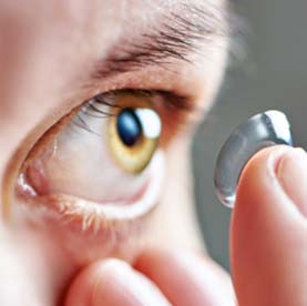 A closeup image of someone putting in contact lenses