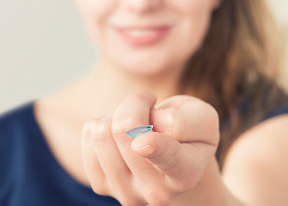 woman holding contact lens