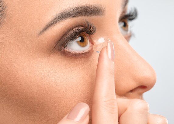 woman putting soft lens